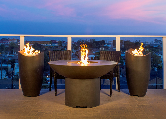 Concrete fire urns burning on a rooftop terrace